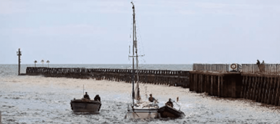 Yacht under tow in Littlehampton Harbour